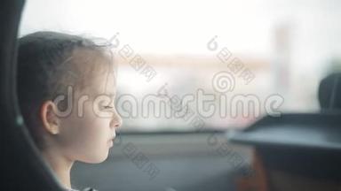 一个小女孩坐在窗边的公共汽车上